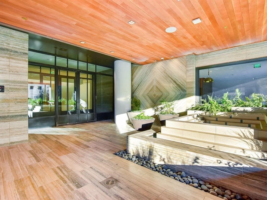 Wood and stone lobby arrival at Fifth & West Residences
