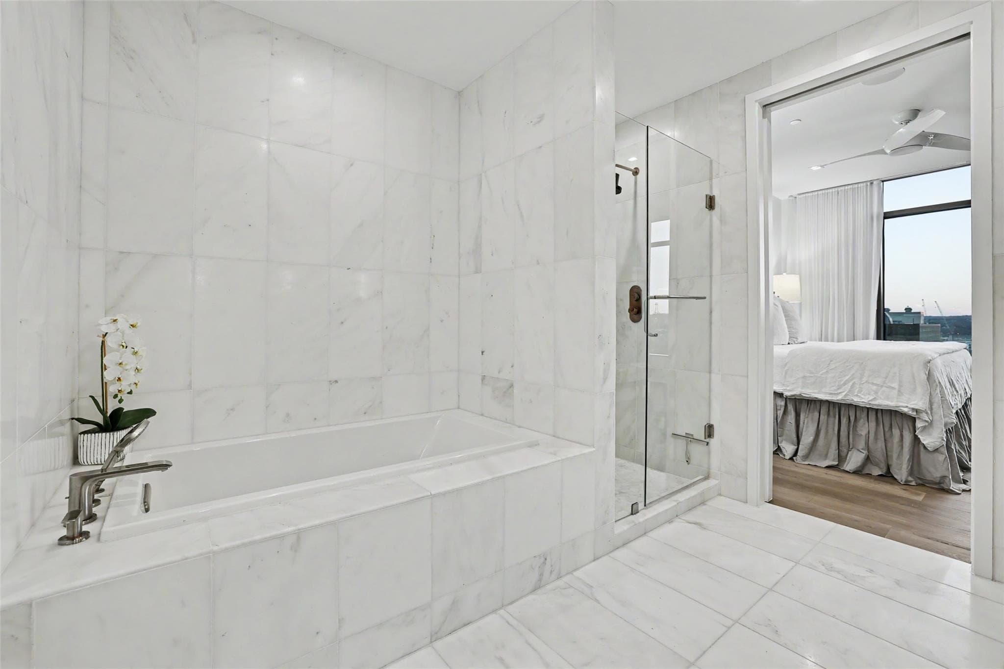Luxurious all-marble bathroom features a deep soa