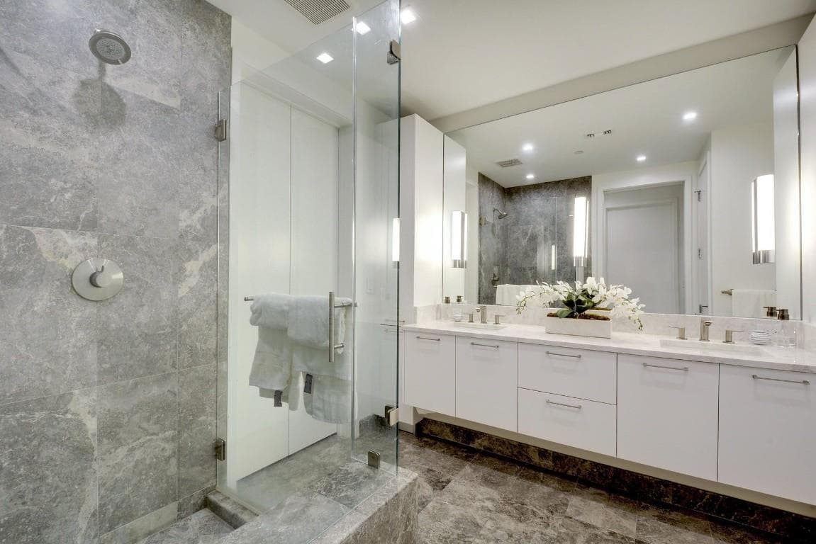 Bathroom with double vanity, a stall shower, tile