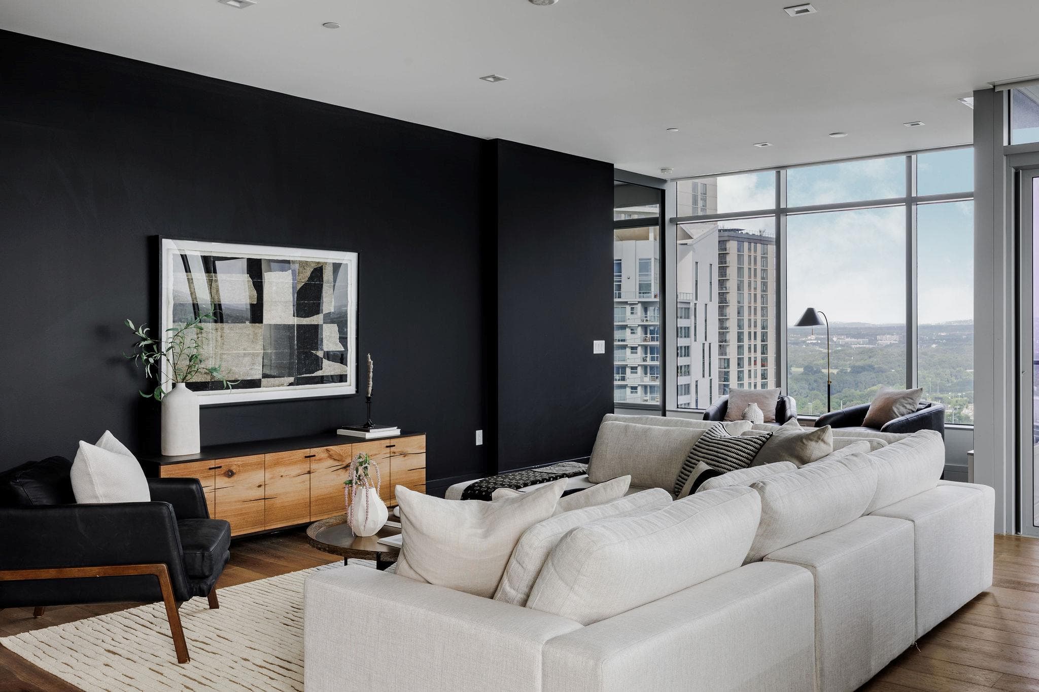 Floor-to-ceiling windows frame cityscape views fr
