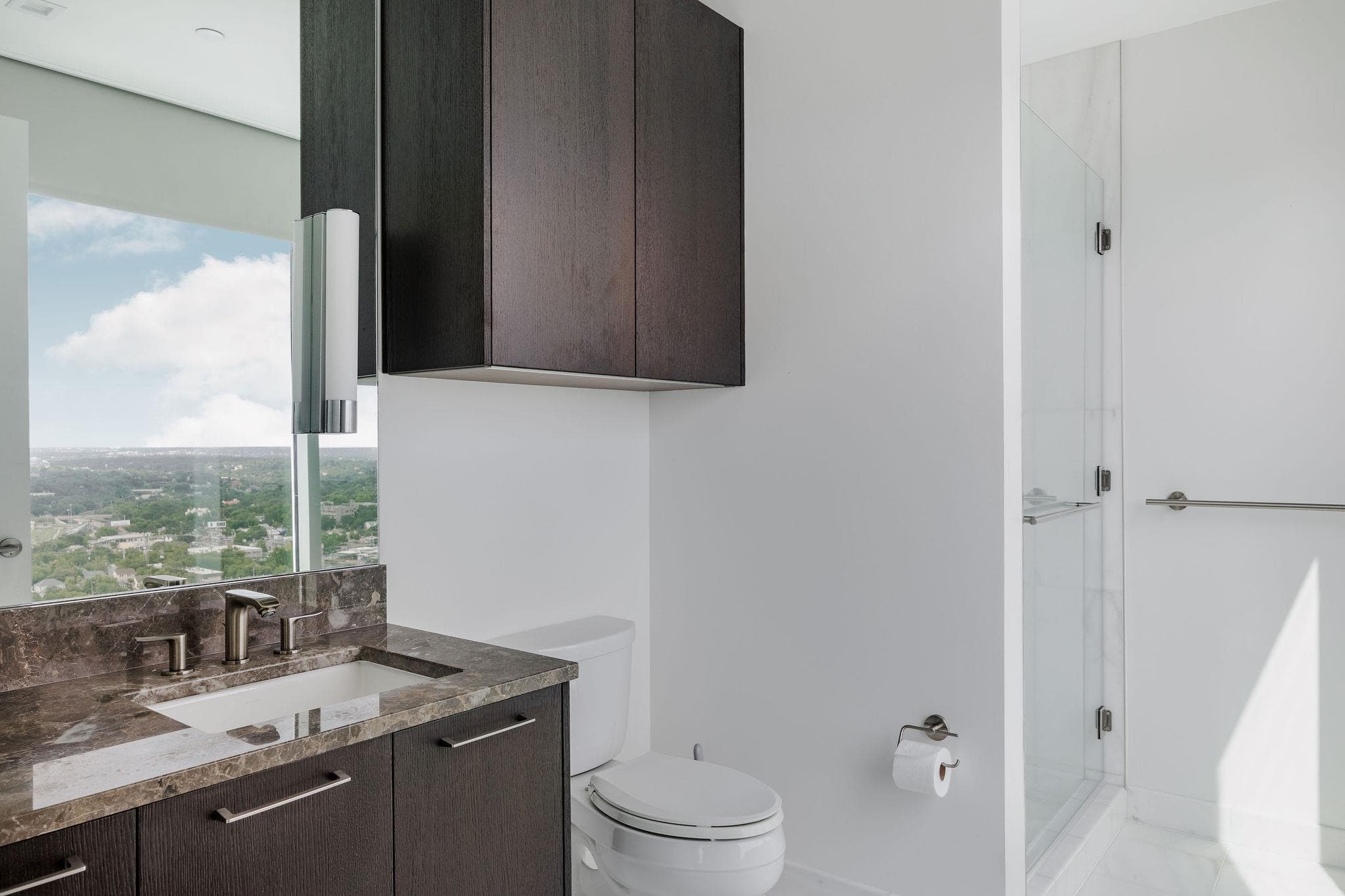 City views frame this modern bathroom with a glas