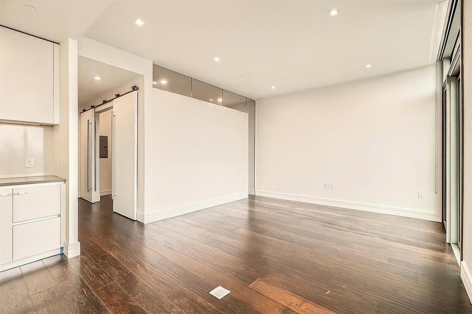 Empty room with a barn door, dark wood-style floo