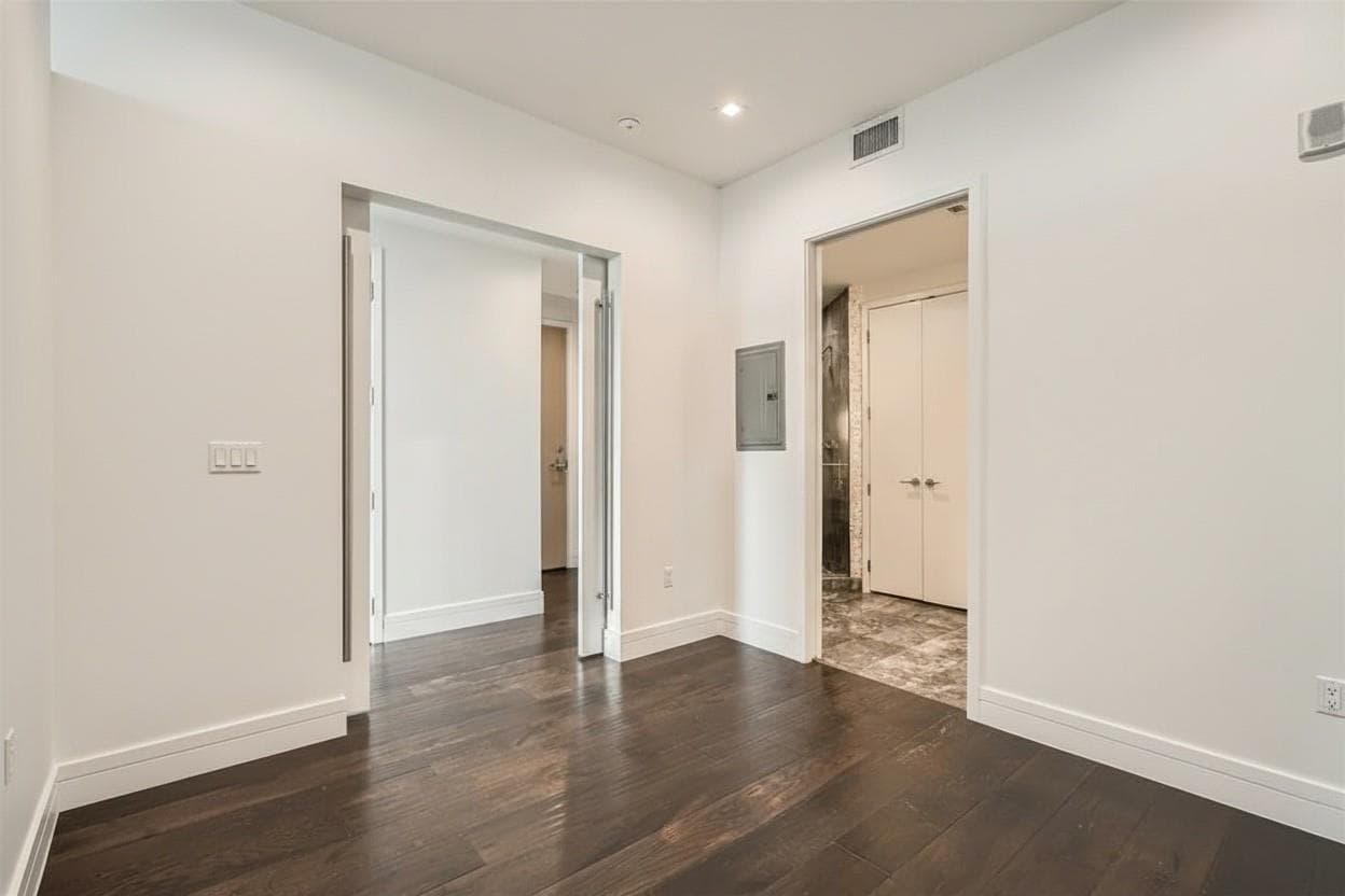 Unfurnished bedroom with dark wood-type flooring,