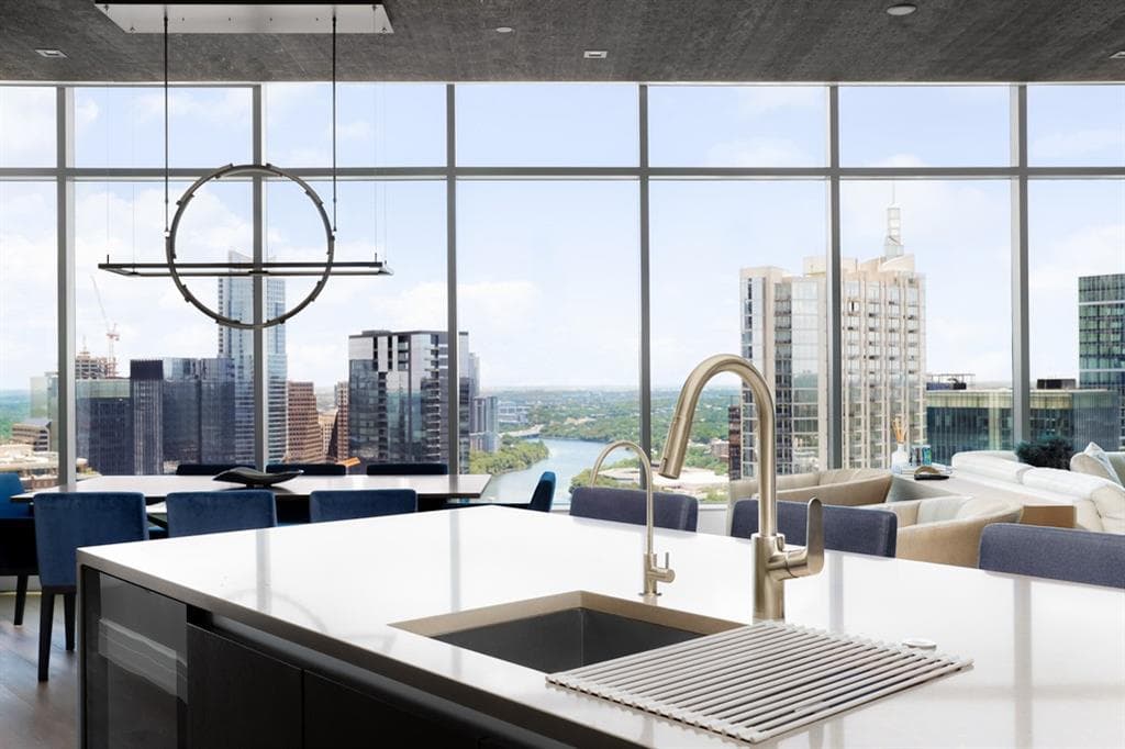 Quartz island kitchen with floor-to-ceiling skyline views at Fifth & West