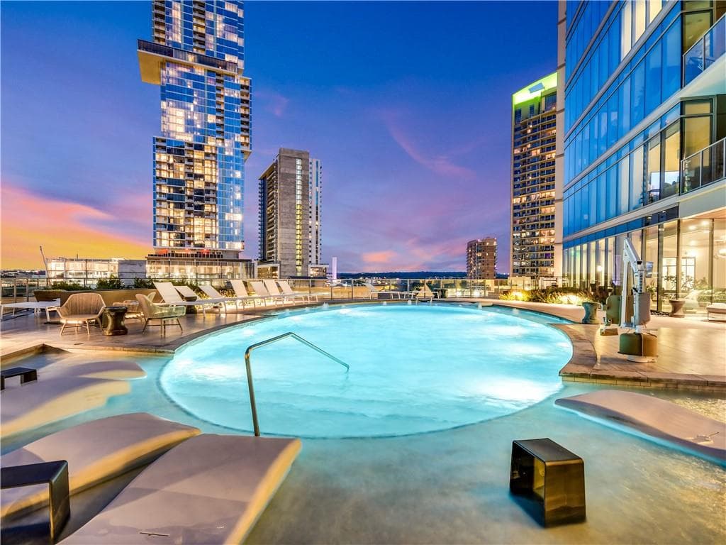 Fifth & West pool deck at dusk with the downtown Austin skyline behind it